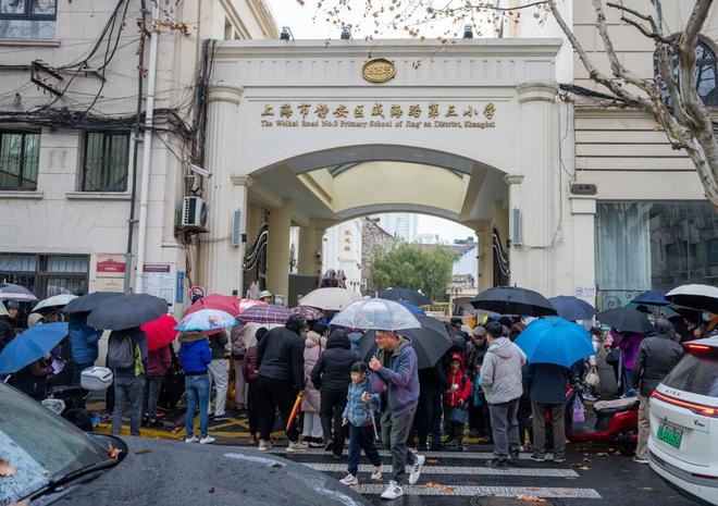 【城事】强冷空气影响上海家长备衣带伞接孩子放学(图1)